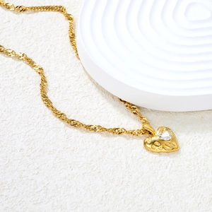 Close-up of 18k gold plated lava heart pendant with a sparkling diamond inlay