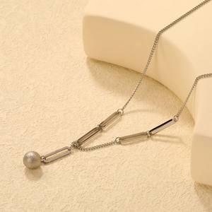 Dettaglio della collana in acciaio argento con pendente a sfera opaca e maglie rettangolari