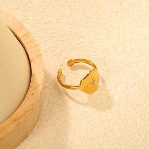 Detailaufnahme des goldenen verstellbaren Rings mit Sternengravur und Zirkonstein