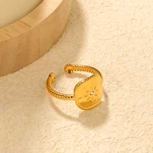 Nahaufnahme von goldfarbenem Seesternring mit Sonnenstern-Gravur und Kordel-Design