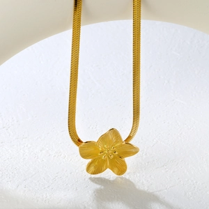Detailed macro view of 18K gold plated flower pendant on a sleek snake bone chain