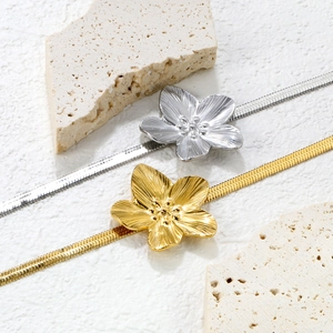 Elegant gold and silver floral petal bracelets with sleek snake chain on natural stone