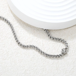 Détail du pendentif rond en zircon sur un collier à chaîne box argentée