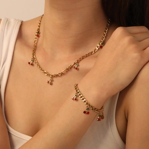Detail of elegant cherry pendant necklace and bracelet set with sparkling red rhinestones