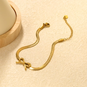 Elegant gold bow charm bracelet with a sleek flat snake chain for women, top view