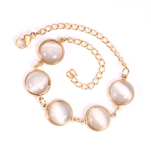 Close-up of gold chain bracelet with five round cat eye stones and adjustable clasp