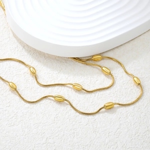 Elegante collana a doppio strato in oro 18k con ciondoli a perline ovali