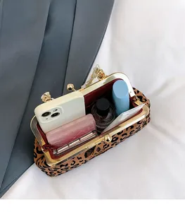 Detail view of leopard print shell bag interior showing storage space and pearl handle