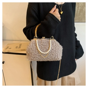 Detailed view of khaki fleece shell bag featuring bamboo handle and pearl chain strap