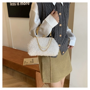 Detail of white faux fur handbag featuring bamboo handle and elegant pearl chain decoration