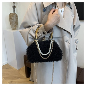 Detail of black faux fur shell bag with bamboo handle and elegant pearl chain accessory