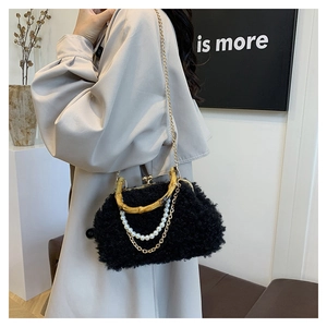 Detail of black faux lamb wool shell bag with bamboo handle and pearl chain decoration