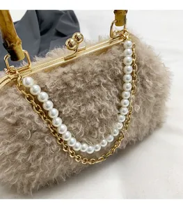Detail view of khaki faux shearling shell bag with bamboo handle and pearl chain strap