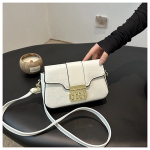 Nahaufnahme der weißen Klapptasche mit Kroko-Prägung und goldenem Doppel-B-Verschluss