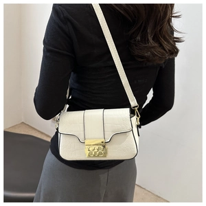 Detail der weißen Schultertasche mit Krokodilmuster und goldenem Doppel-B-Magnetverschluss