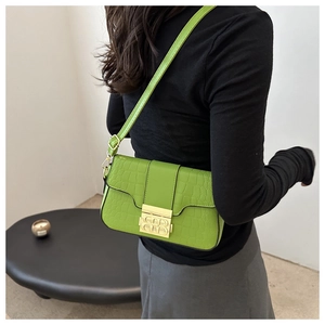 Detail der grünen Crossbody-Tasche mit Kroko-Prägung und goldenem B-Verschluss