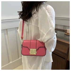 Detail der rosa Tasche mit Krokodilprägung und goldenem Metallverschluss für Damen