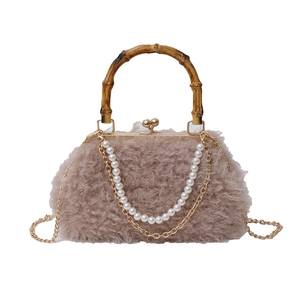 Faux shearling handbag with bamboo handle, pearl chain and metal strap on white background