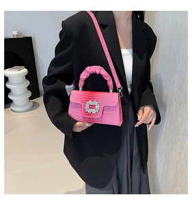 Pink faux crocodile leather bag featuring a sparkling rhinestone buckle and ruched handle