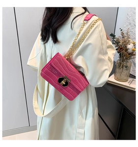 Detail of rose pink crocodile embossed chain bag with gold T-lock and glossy finish