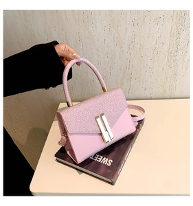 Nahaufnahme der rosa Pailletten-Handtasche mit eleganten goldenen Schnallen und Riemen