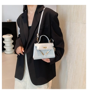 Silver glitter mini handbag shown on a model in a black blazer with a shoulder strap