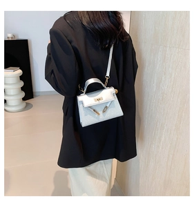 Detalle de mini bolso Kelly de lentejuelas plateadas con cierre dorado y correa