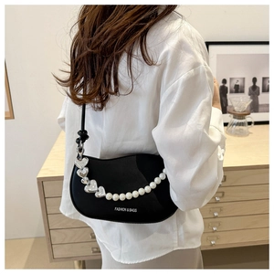 Détail du sac demi-lune noir en similicuir avec perles et boucle en forme de cœur argenté