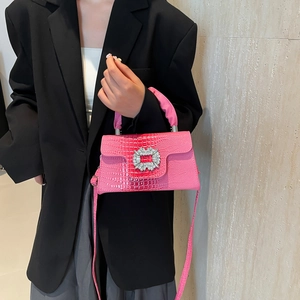 Chic lizard-patterned handbag in bright pink featuring a sparkling crystal buckle detail