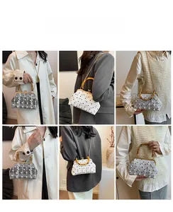 Detail view of retro handbag with bamboo handle, pearl accents and metal clasp closure