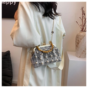 Detail of grey plaid tweed handbag with pearl embellishments and bamboo handle