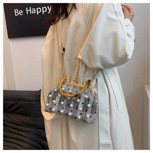 Detail of checkered bag with pearl accents, bamboo handle, and gold chain strap