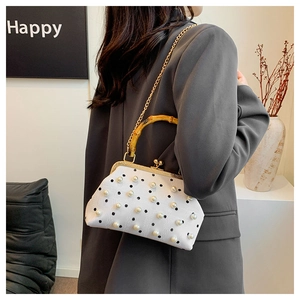Detail of white pearl handbag with bamboo handle, gold chain and vintage metal clasp