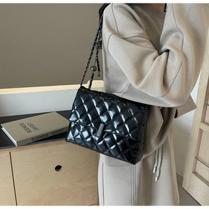 Sac chic en cuir noir matelassé avec bandoulière chaîne dans un cadre lifestyle élégant