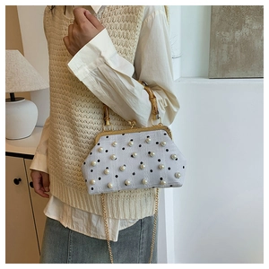 Close-up of retro polka dot handbag featuring pearl accents and bamboo handle detail