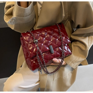 Gros plan d'un sac à bandoulière matelassé bordeaux avec chaîne et fermoir argentés
