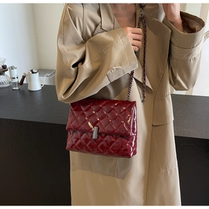 Détail du sac bandoulière en cuir matelassé bordeaux avec chaîne sur un mannequin