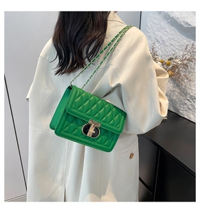 Détail du sac matelassé vert avec fermoir doré en T et bandoulière en chaîne