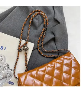 Détail du sac matelassé caramel avec bandoulière réglable à boule argentée