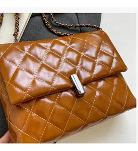Vue rapprochée du sac en cuir matelassé marron avec un fermoir métallique argenté poli