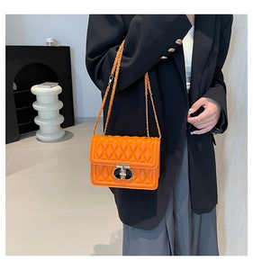 Détail du sac bandoulière matelassé orange avec fermoir doré et bandoulière chaîne