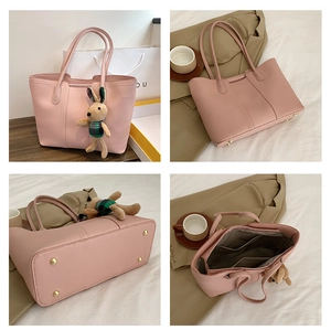 Dettagli della borsa tote in pelle rosa con rivetti sul fondo e tasca interna con zip