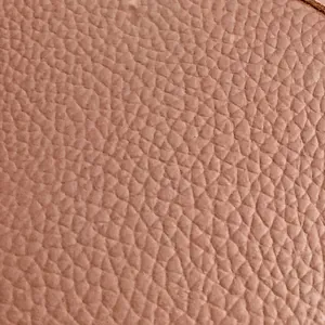 Dettaglio ravvicinato della trama in pelle litchi sulla borsa a mano malva