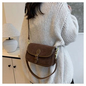 Retro dark brown suede flap bag with buckle detail worn over a cream knit sweater