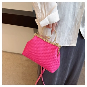 Detail of rose pink woven texture bag with gold metal handle and pearl clasp closure