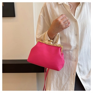 Detail of hot pink woven texture handbag featuring gold clasp with pearl accent