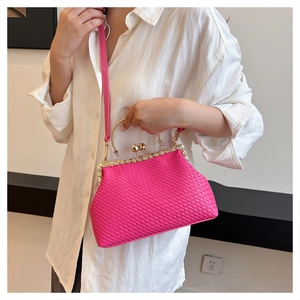 Detail of rose pink woven texture bag with gold metal handle and pearl decorative clasp