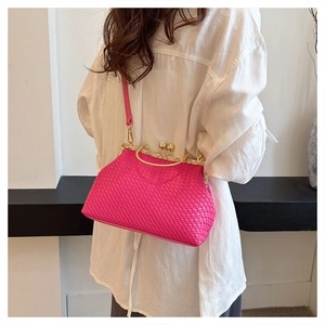 Detail view of woven rose red handbag with vintage gold metal clasp and leather strap
