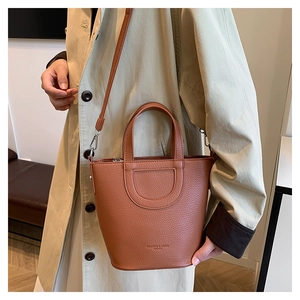 Brown lychee grain bucket bag with round handle and adjustable strap for shoulder wear