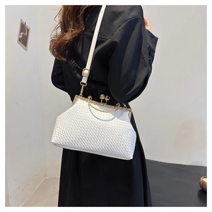 Detail of white woven texture handbag featuring gold clasp closure and elegant bead detail